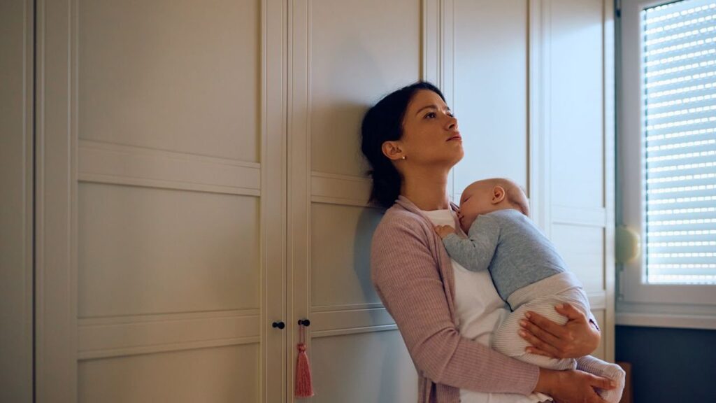Traurige Mutter hält ihr Baby m Arm